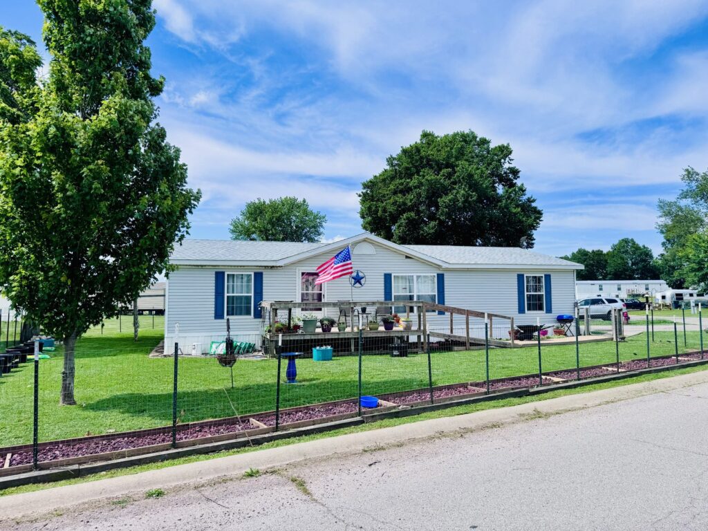 Manufactured home with deck at Cedar Glen Mobile Home Park in Aurora, MO