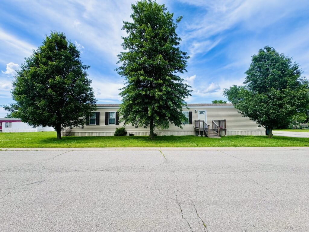 Homes shaded by tall trees at Cedar Glen Mobile Home Park, Aurora, MO